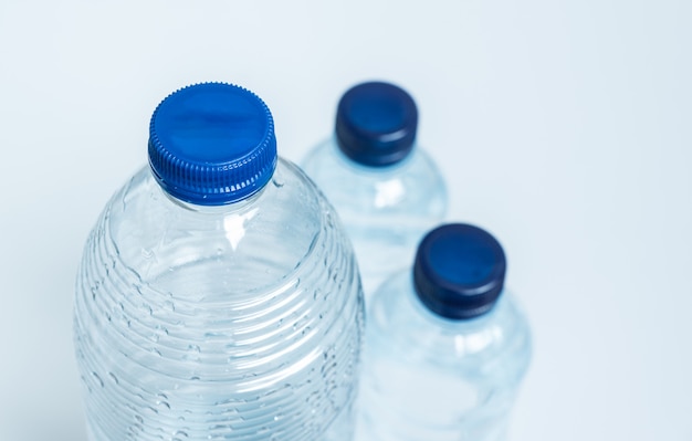 Trois bouteilles en plastique vides avec bouchons bleus