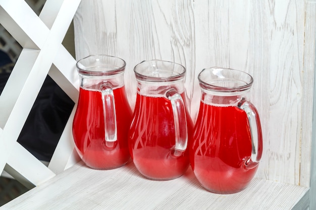 Photo trois carafes à jus de fruits rouges sur le buffet. photo horizontale