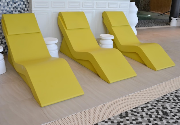 Trois chaises longues jaunes dans la piscine