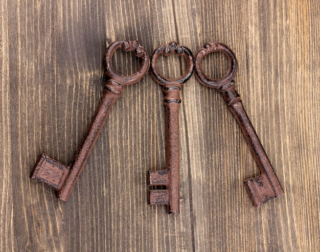 Trois clés antiques sur fond de bois
