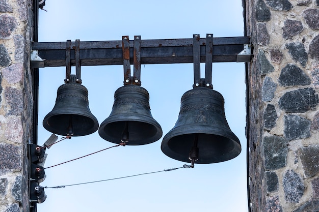 Trois cloches sont accrochées au clocher de l'église chrétienne. photo de haute qualité