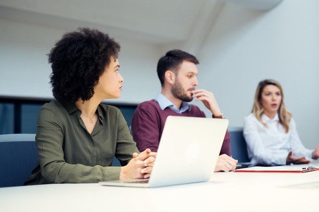 Trois collègues sont dans une salle de conférence.