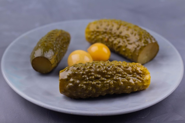 Trois cornichons sur une assiette