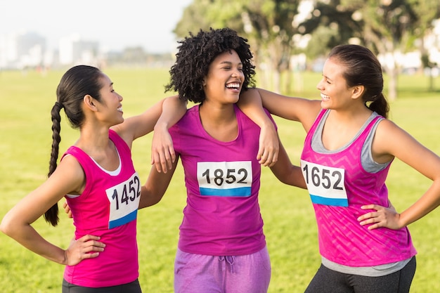 Trois coureurs en riant soutenant le marathon du cancer du sein