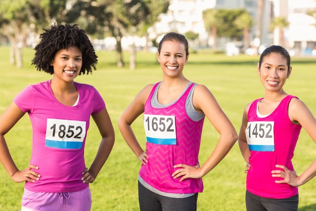 Trois coureurs souriants soutenant le marathon du cancer du sein