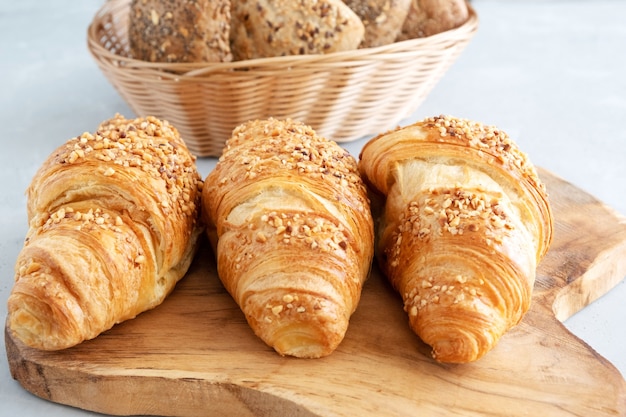 Trois croissants français traditionnels frais sur une planche de bois