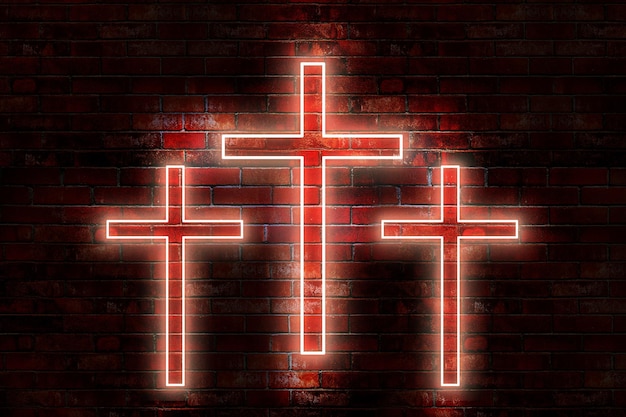 Trois croix sur un mur de briques avec le mot Jésus dessus.