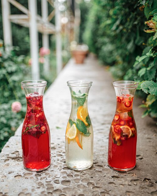 Trois cruches en verre de limonade de baies et de fruits frais