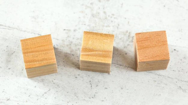 Trois cubes de jeu en bois vierges sur tableau blanc