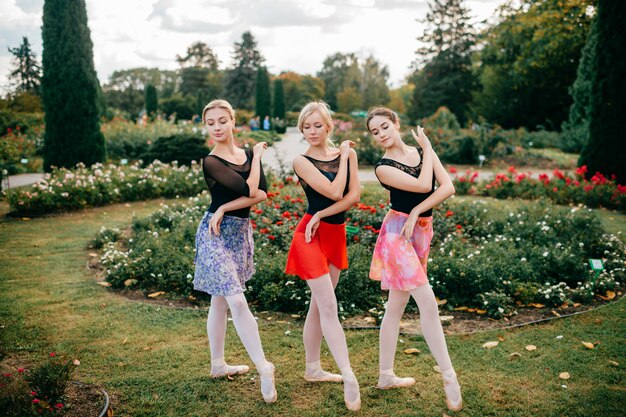 Trois danseurs de ballet gracieux posant et dansant en été beau parc