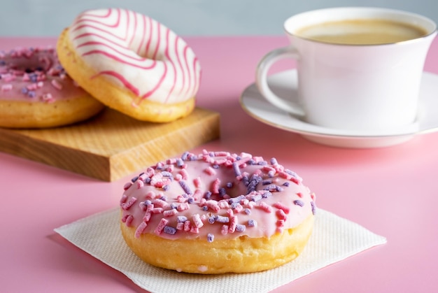 Trois délicieux beignets glacés frais et une tasse de café chaud frais