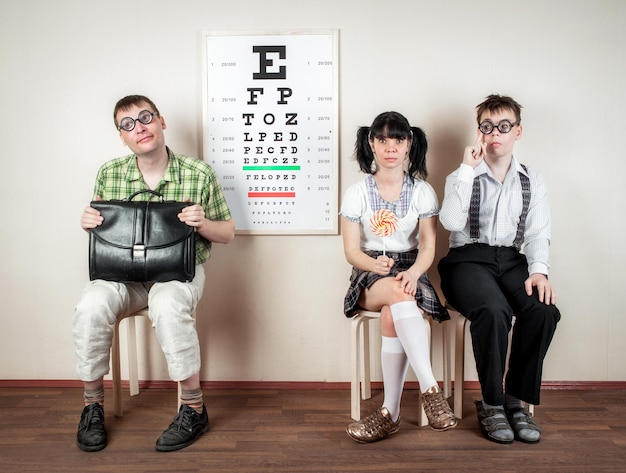 Trois drôles de personnes portant des lunettes dans un bureau chez le médecin