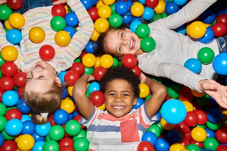 Photo trois enfants heureux jouant dans ballpit