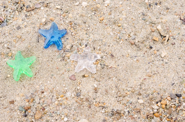 Trois étoiles décoratives sur fond de sable de plage avec un espace de copie, le concept de vacances dans un hôtel trois étoiles