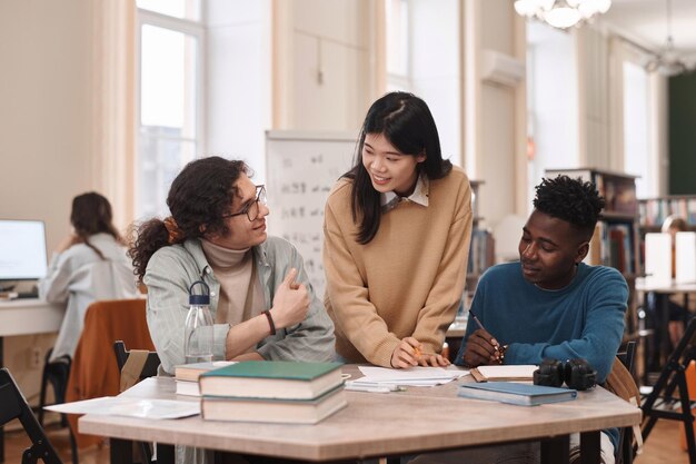 Trois étudiants qui étudient à la bibliothèque