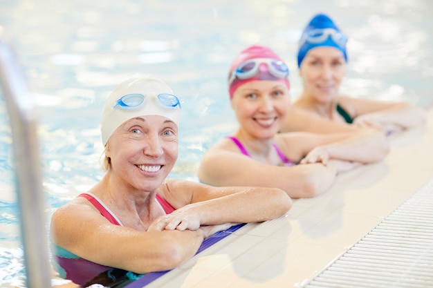 Trois femmes matures posant dans la piscine