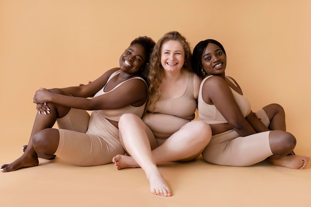 Photo trois femmes en modeleurs de corps nus posant ensemble