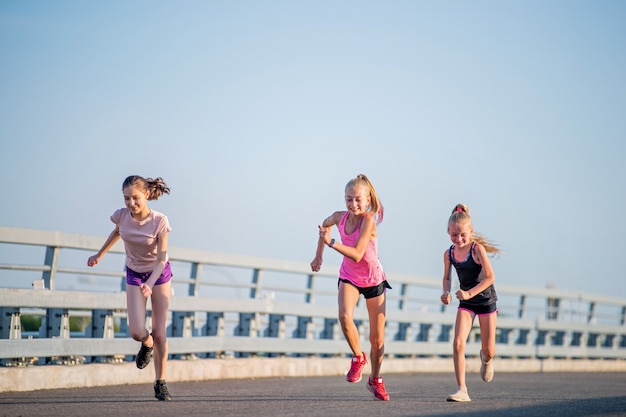 Trois filles jogging sur une soirée d'été ensoleillée