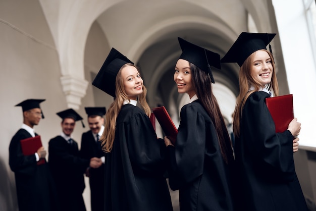 Trois filles posent pour une caméra à l'université.