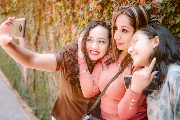 Trois filles prenant un selfie dans la rue ont l'air heureuses parce qu'elles s'aiment tellement