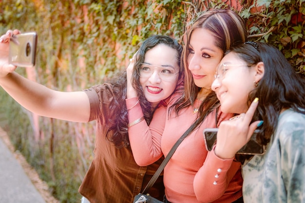 Trois filles prenant un selfie dans la rue ont l'air heureuses parce qu'elles s'aiment tellement