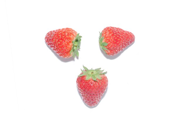 Trois fraises sur fond blanc