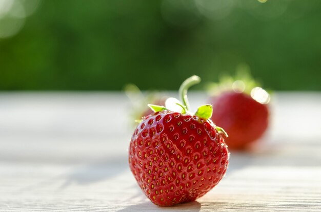 Trois fraises sur une table en bois