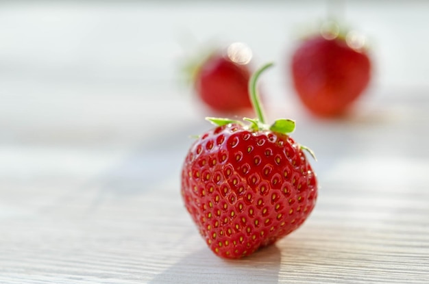 Trois fraises sur une table en bois