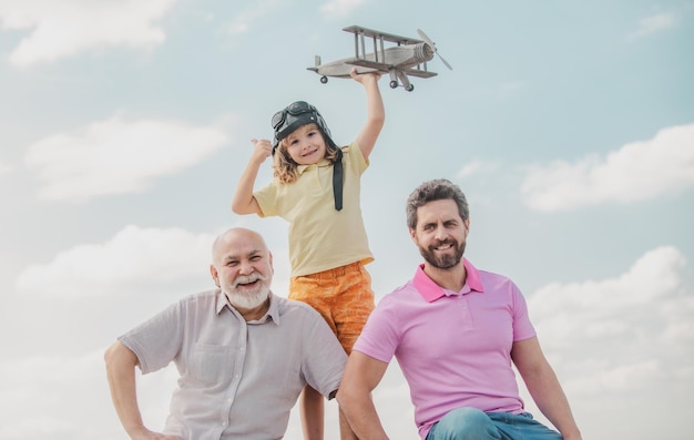Trois générations d'hommes ensemble portrait de fils souriant père et grand-père avec un avion jouet Enfant garçon jouant avec l'avion et rêvant de l'avenir Démarrer le concept de démarrage de la créativité