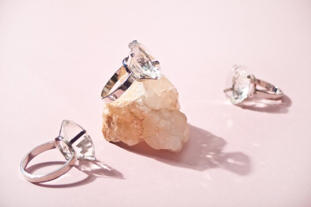 Trois grandes bagues en diamant et un morceau de pierre avec une ombre dure.