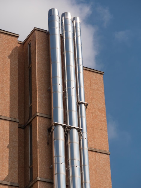 Trois grands tuyaux d'acier verticaux attachés au mur extérieur d'un bâtiment