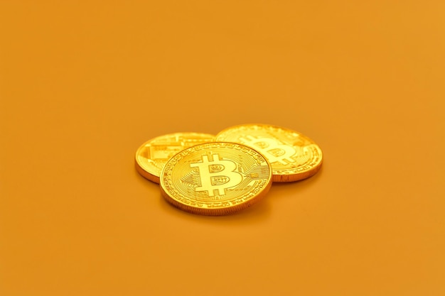 Trois haricots bitcoin jaunes posés sur une surface plane