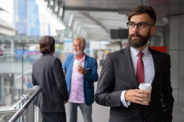 Trois hommes d'affaires barbus multiethniques ensemble autour de la ville