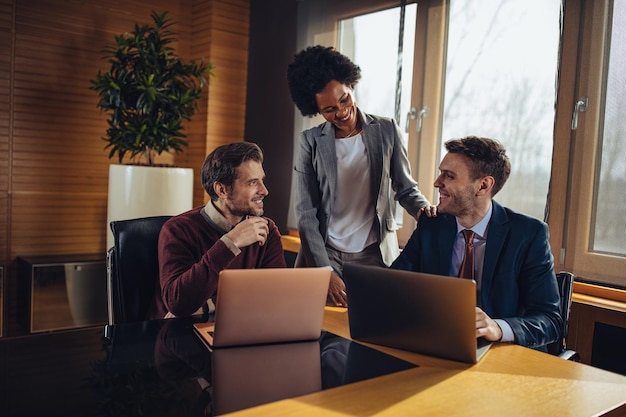 Trois hommes d'affaires travaillant ensemble sur un ordinateur portable au bureau