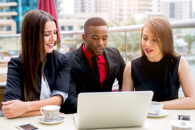 Trois hommes d'affaires travaillant sur ordinateur portable en plein air.