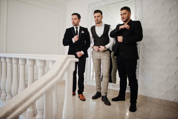 Trois hommes barbus élégants bien habillés ont posé des gars du groupe de musiciens