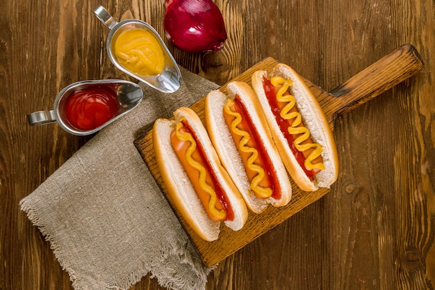 Trois hot-dogs classiques avec du ketchup et de la moutarde