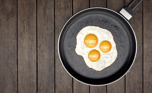 Photo trois jaune d'oeuf sur la poêle sur des lattes de bois