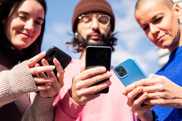 Trois jeunes amis à l'aide de téléphones portables