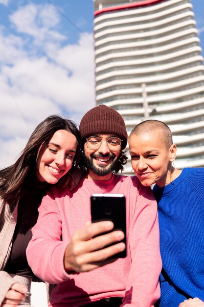 Trois jeunes amis s'amusant avec un téléphone