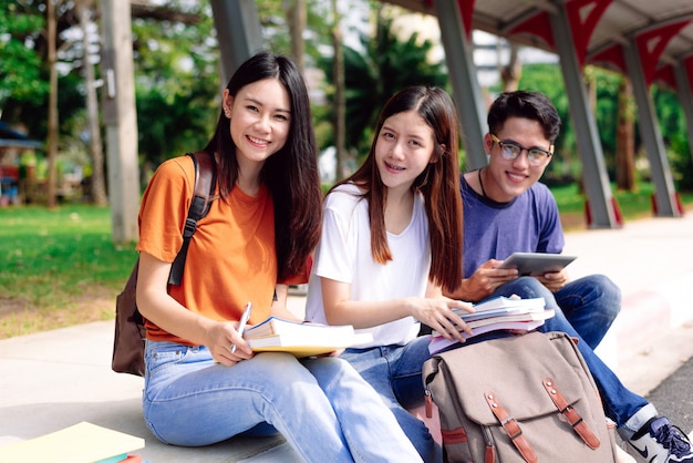 Trois jeunes asiatiques étudient ensemble à l&#39;extérieur