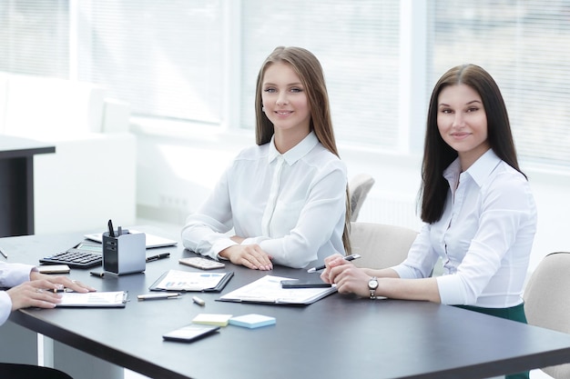 Trois jeunes employés assis derrière un bureau