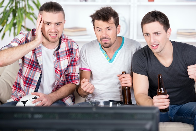 Trois jeunes fans de football se réjouissent d&#39;un match de football.