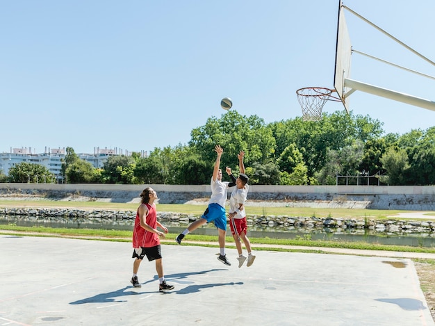 Trois jeunes joueurs sur le terrain de basket