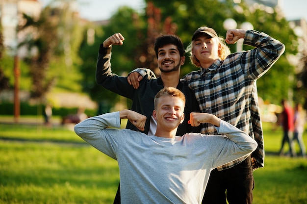 Trois mecs multiethniques ont posé en plein air.