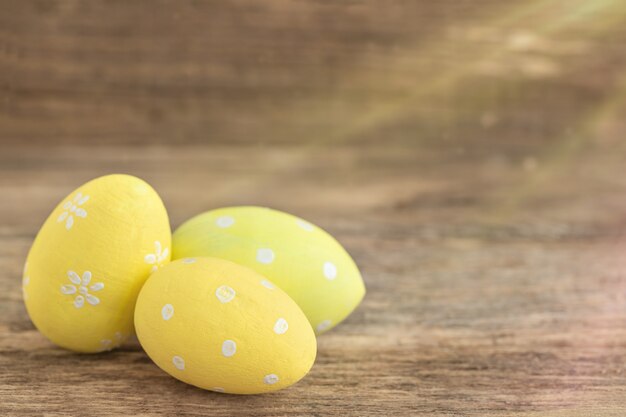 Trois oeufs de Pâques de couleur jaune couché sur bois