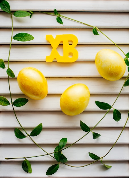 Photo trois oeufs de pâques de couleur jaune sur fond blanc.