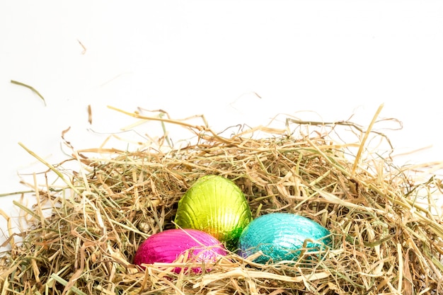 Trois oeufs de Pâques nichés dans un nid de paille