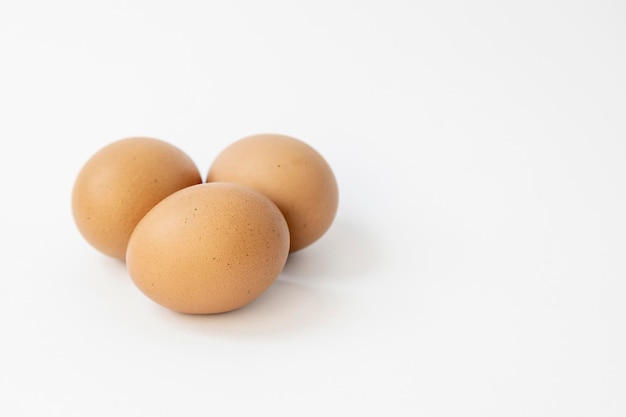 Trois oeufs de poule isoler sur fond blanc