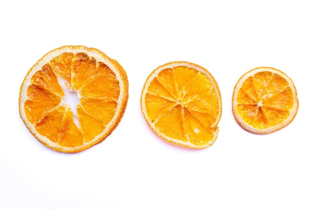 Trois oranges sont coupées en deux sur un fond blanc.